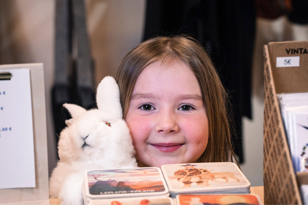 Tyttö Arktikumin kaupassa pehmopupua pidellen.