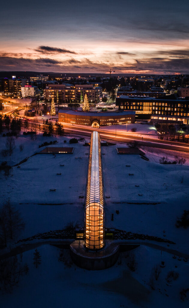 Arktikumin lasiputki talvella kaupungin iltavalaistuksessa.